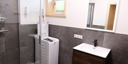 Hüttendorf - Chaletgröße: 6 - 8 Personen - Tamsweg - Badezimmer mit Dusche und Waschmaschine im Erdgeschoss - Designchalets Heidialm-Falkertsee