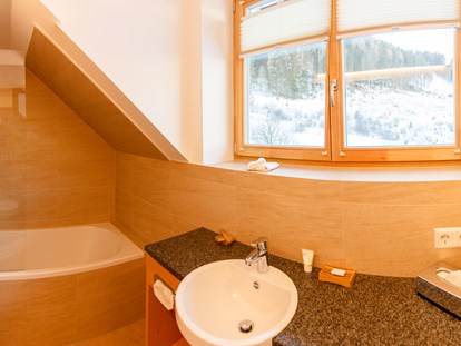 Hüttendorf - Skiraum: im Chalet - Badezimmer mit Badewanne - Trattlers Hof-Chalets