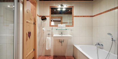 Hüttendorf - Mallnitz - Badezimmer en suite mit Badewanne/Dusche/WC/Fön/Kosmetikspiegel - Almdorf Flachau